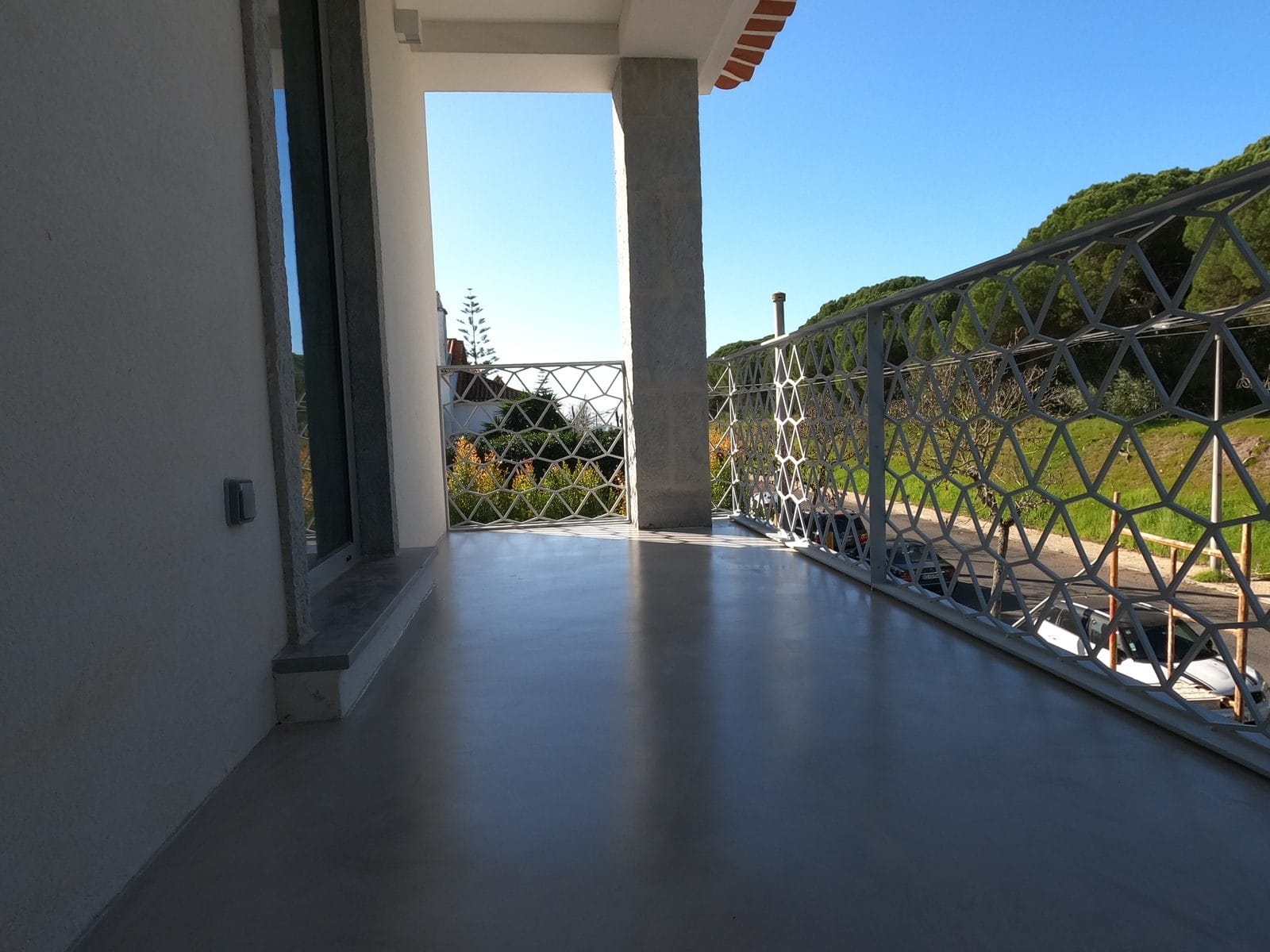 Varanda corrida em microcimento exterior com vista, pavimento contínuo — KCBerry