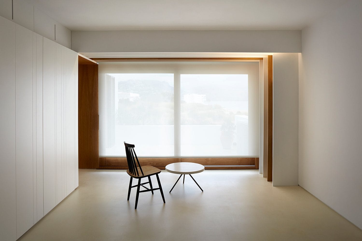 Pavimento em microcimento em sala com grande vão envidraçado e luz natural — KCBerry