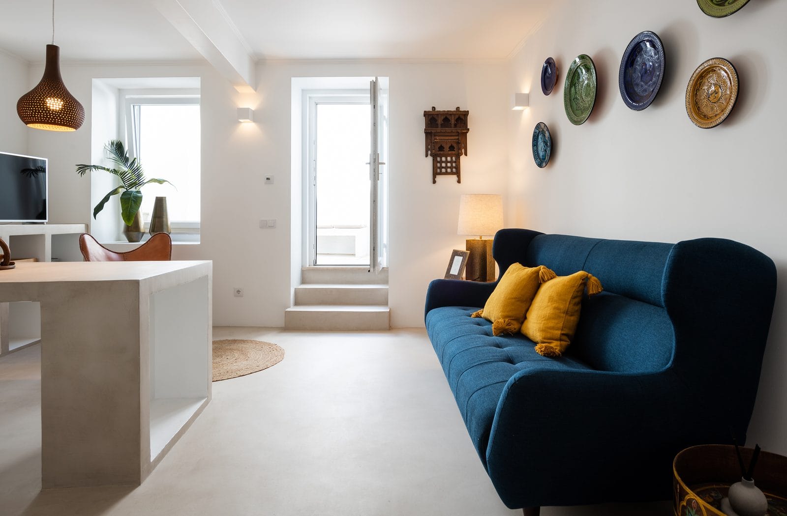Sala de estar com pavimento em microcimento claro e paredes brancas — KCBerry